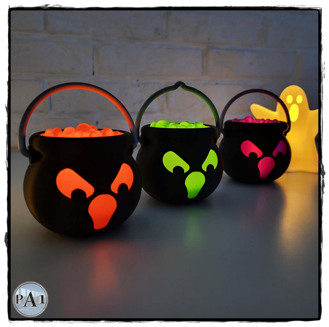 Halloween LED cauldron tea light holders with vibrant colored accents and a glowing ghost decoration.