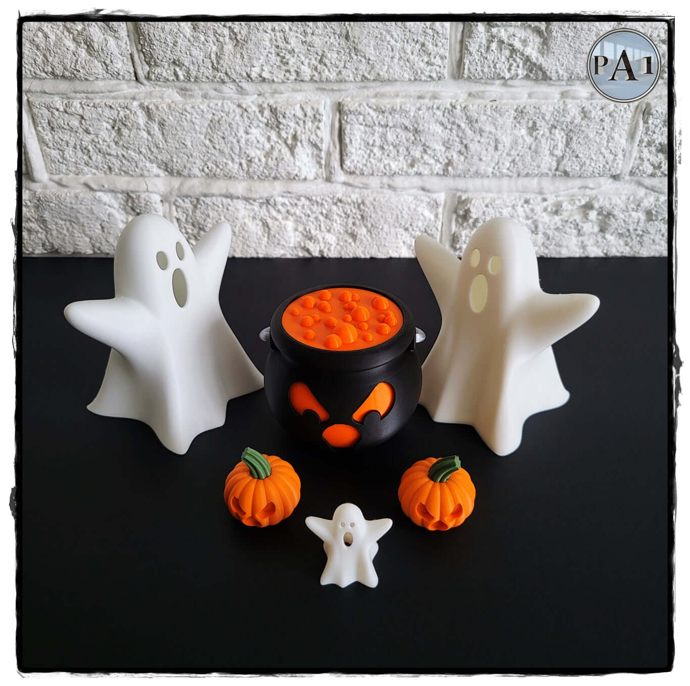 Halloween decor featuring ghost-shaped tea light holders and a cauldron with pumpkin accents.