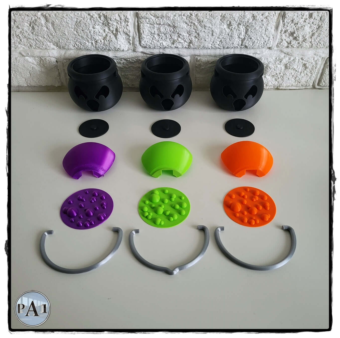 Halloween LED cauldron tea light holders with colorful accents and removable parts for festive decoration.